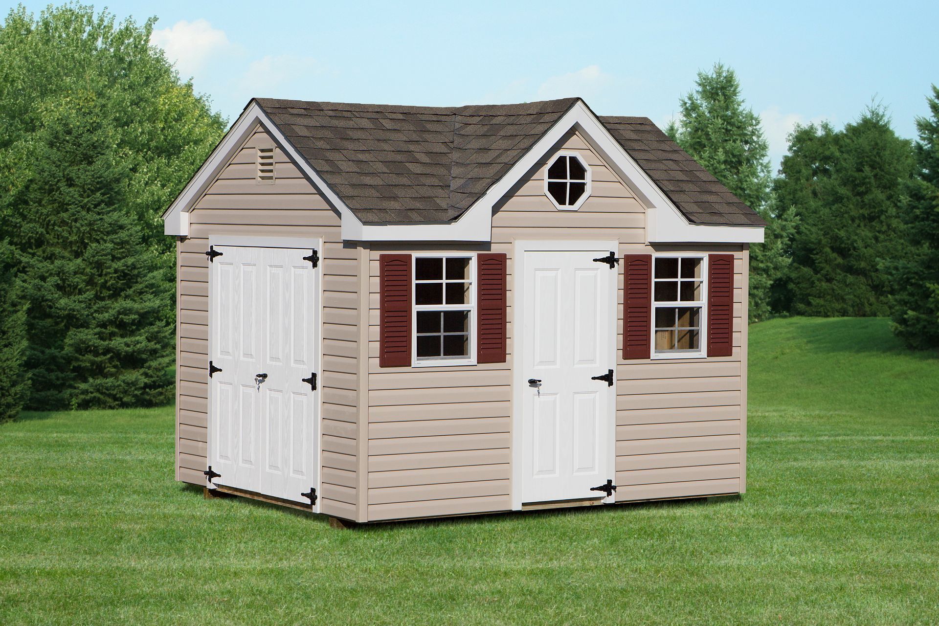 Tan shed with brown roof, white doors, and red shutters, set in a grassy yard.