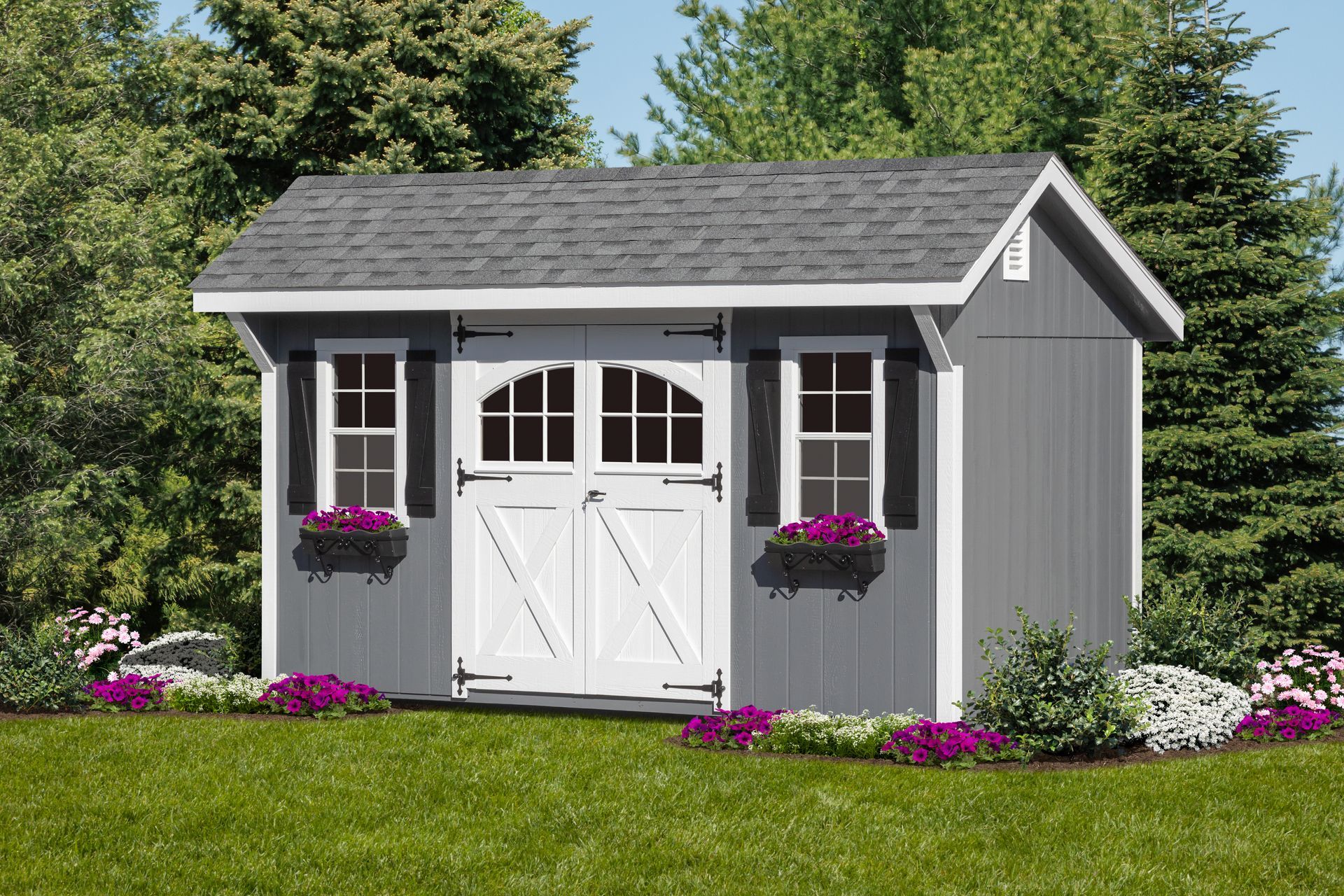 Gray storage shed with white doors, shutters, and flower boxes in a grassy yard.