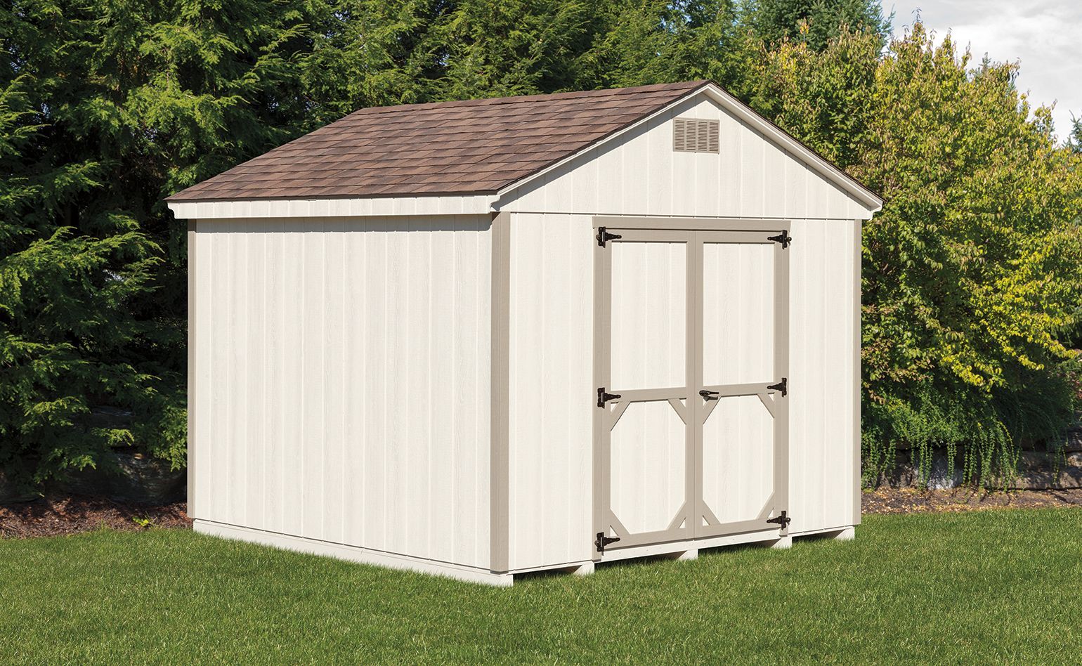 White shed with brown roof and beige door frame on green grass.