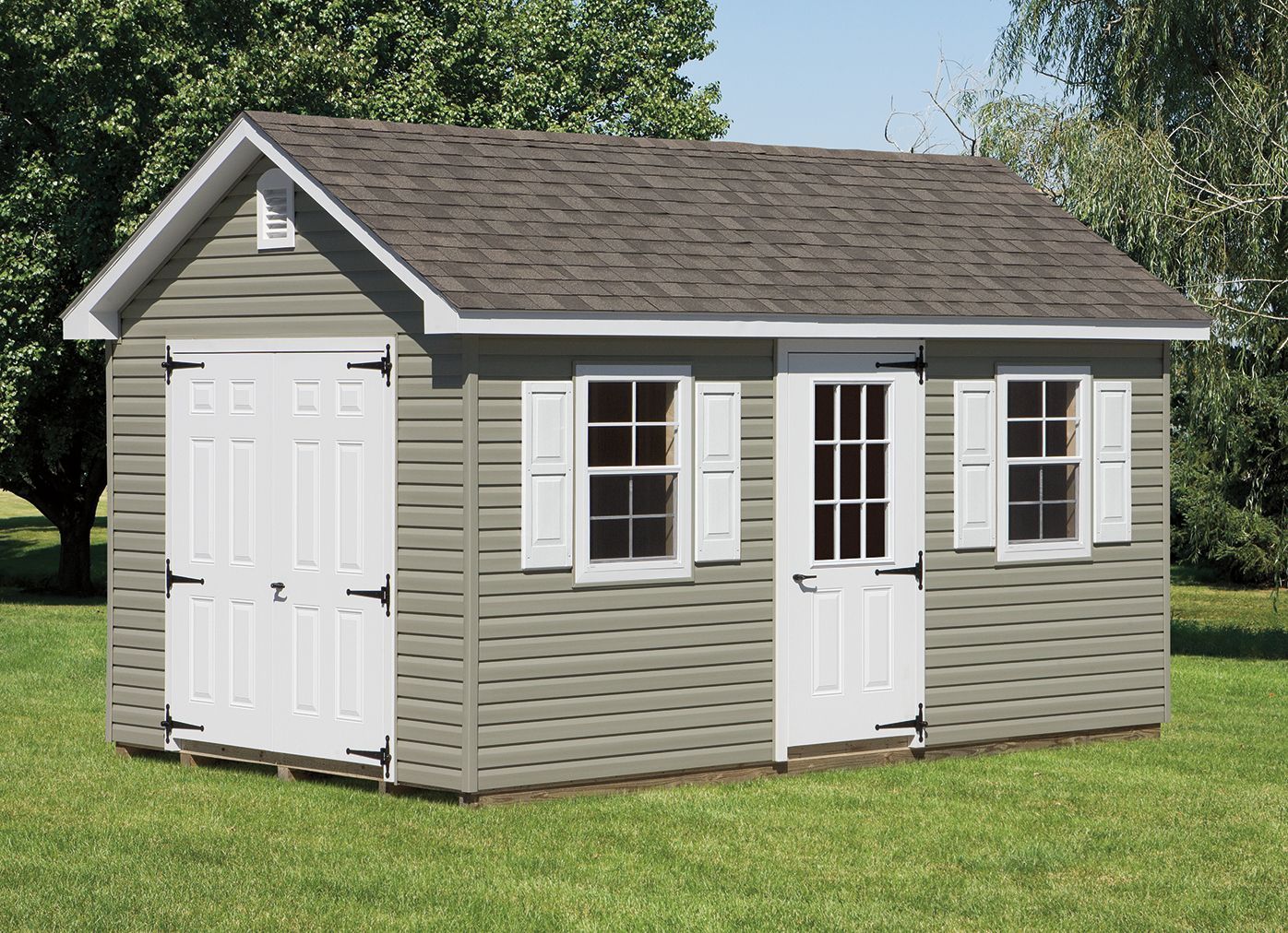 Gray shed with white doors, windows, and shutters; brown roof. Set on green grass.