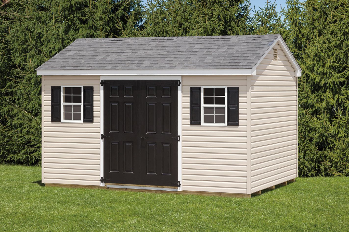 Beige shed with black double doors, two windows, and gray roof, in a grassy yard.