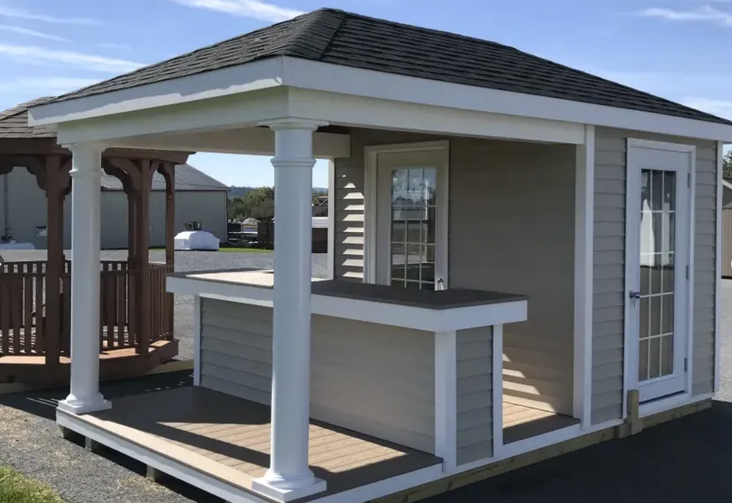 Outdoor bar structure with gray siding, white trim, and a black shingled roof.