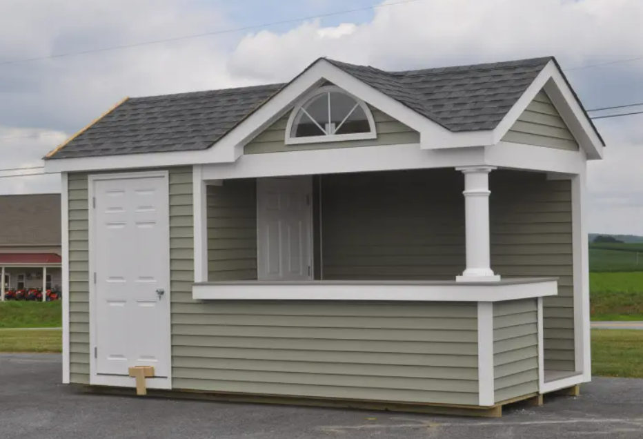Green and white food stand with a partial door, window, and small arch window.