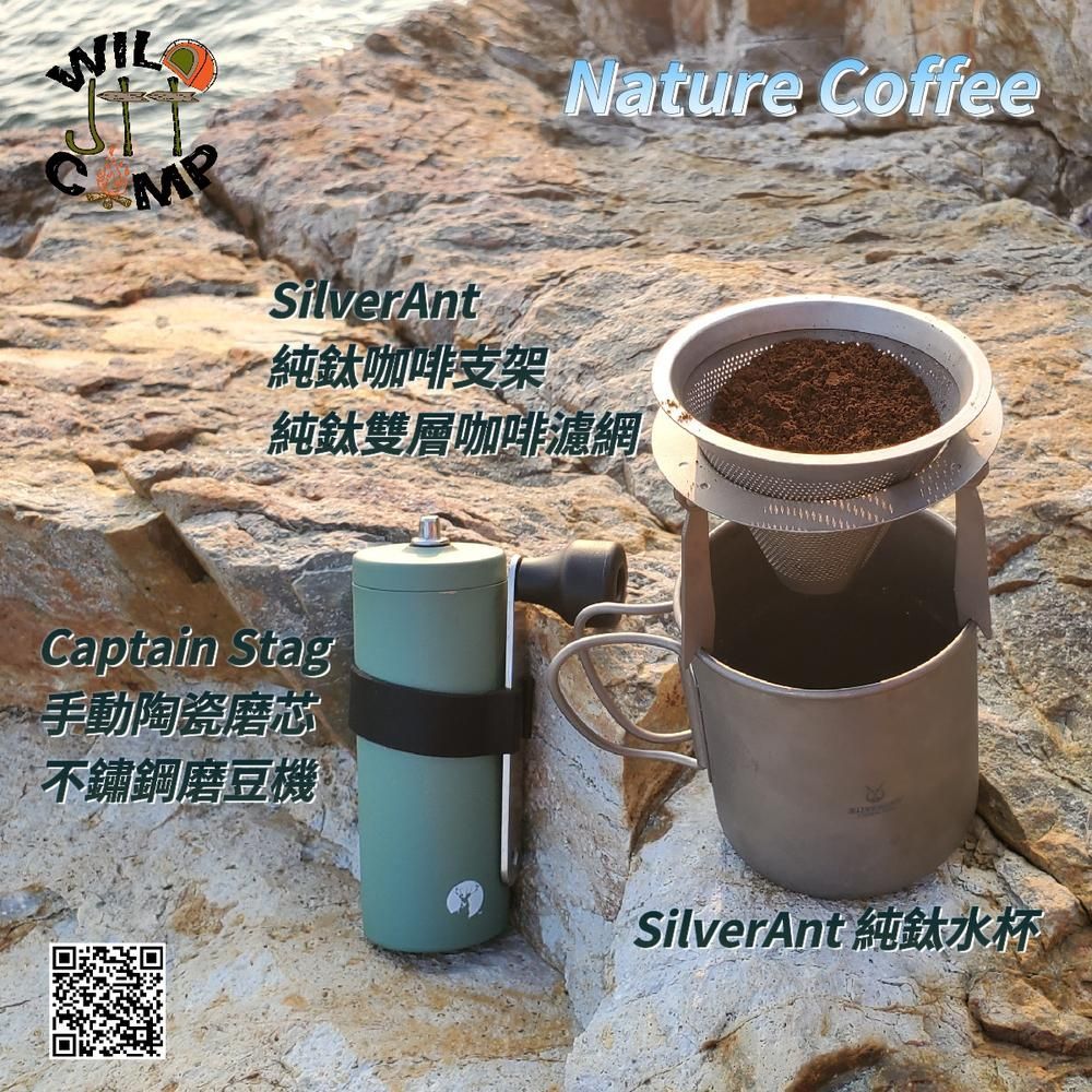 一張咖啡機和一杯放在岩石上的咖啡的照片。