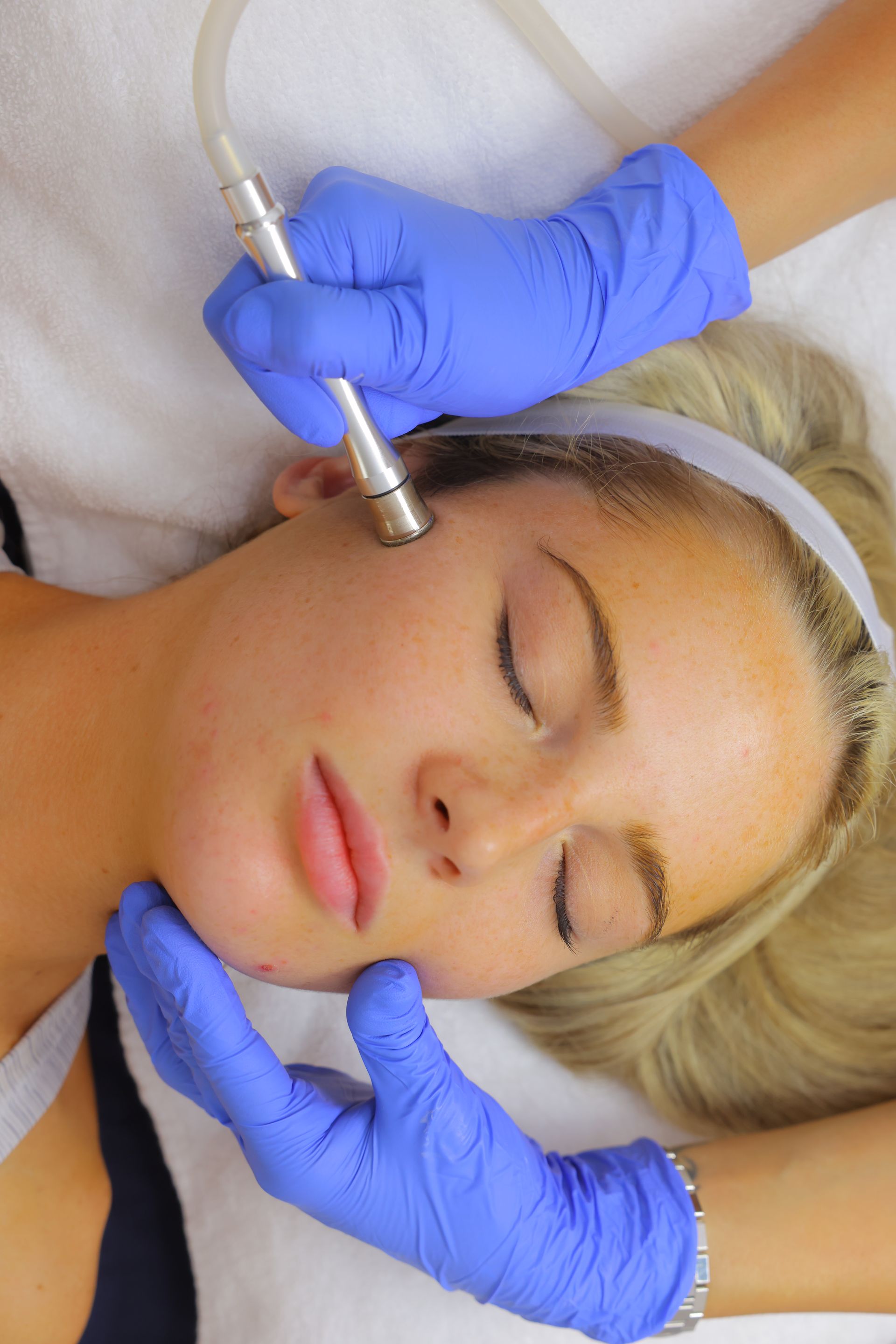 A woman is getting a facial treatment at a beauty salon.