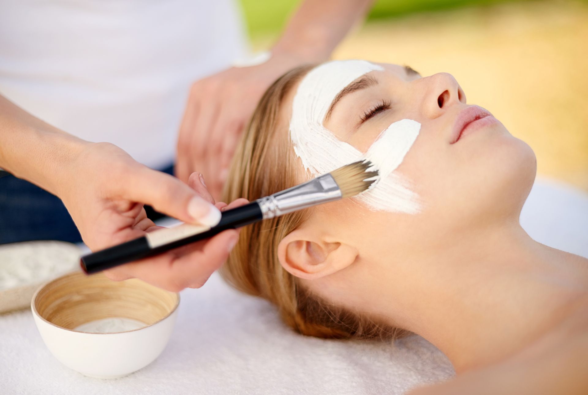 A woman is getting a facial treatment at a spa.