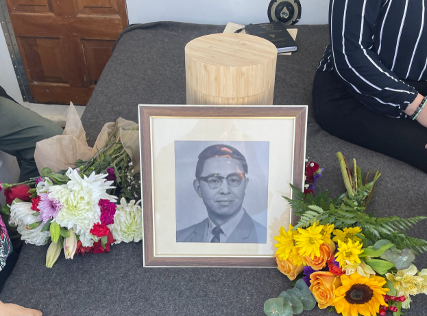 A framed picture of a man is surrounded by flowers