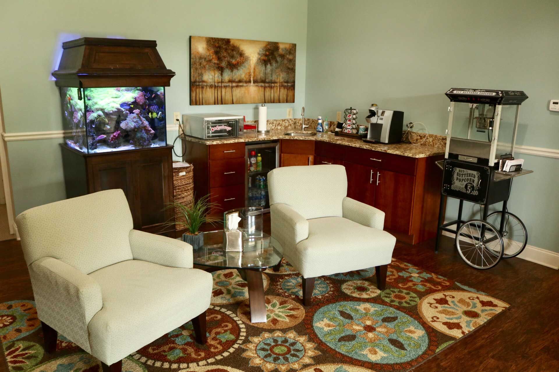 A living room with two chairs and a fish tank