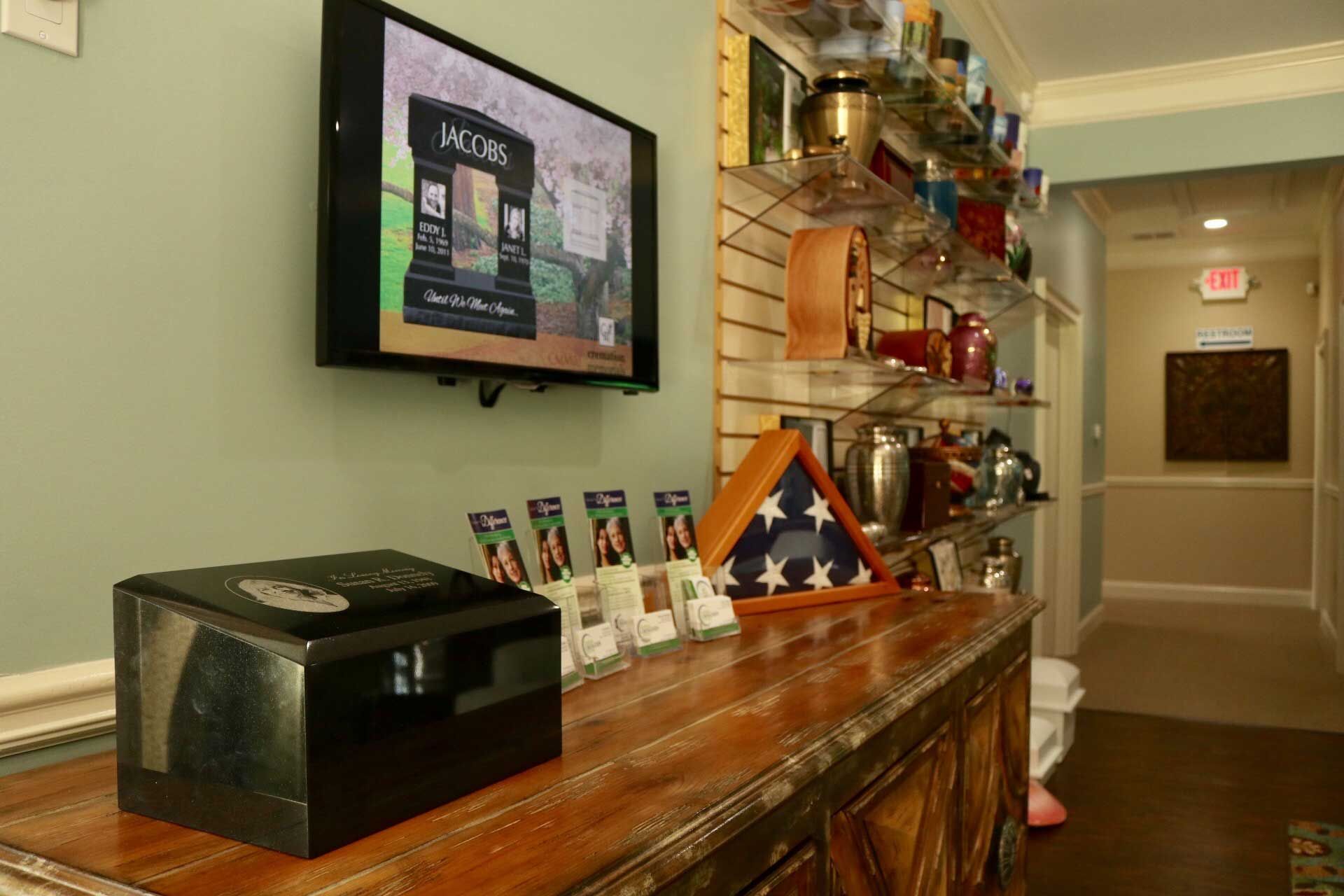 A television is hanging on the wall above a wooden table.