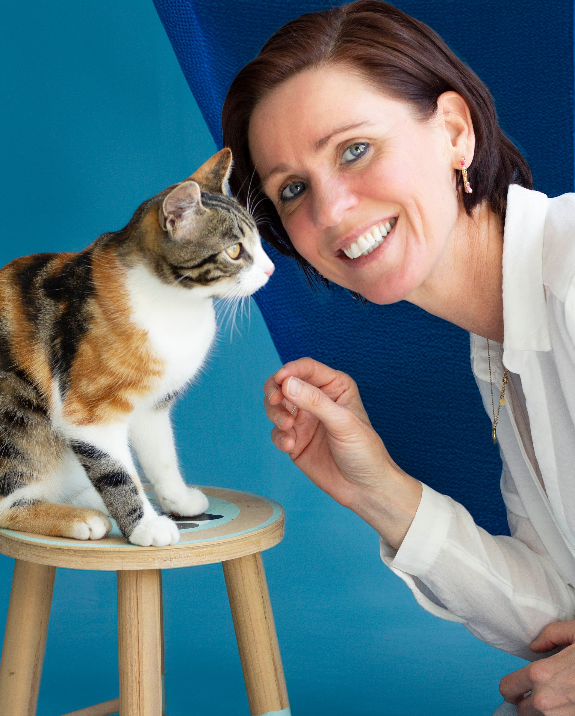 Een meisje in een gestreepte trui aait een bruin paard, beide tegen een donkere achtergrond.