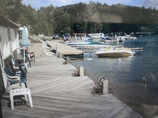 A dock with chairs and umbrellas next to a body of water