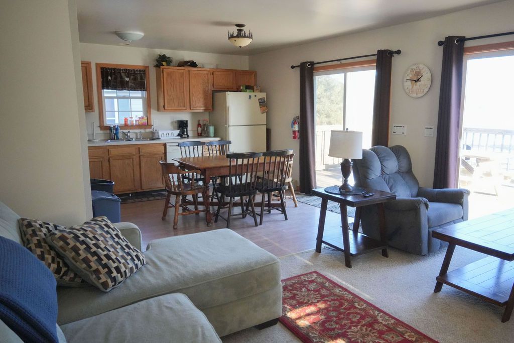 A living room with a couch a chair a table and a refrigerator
