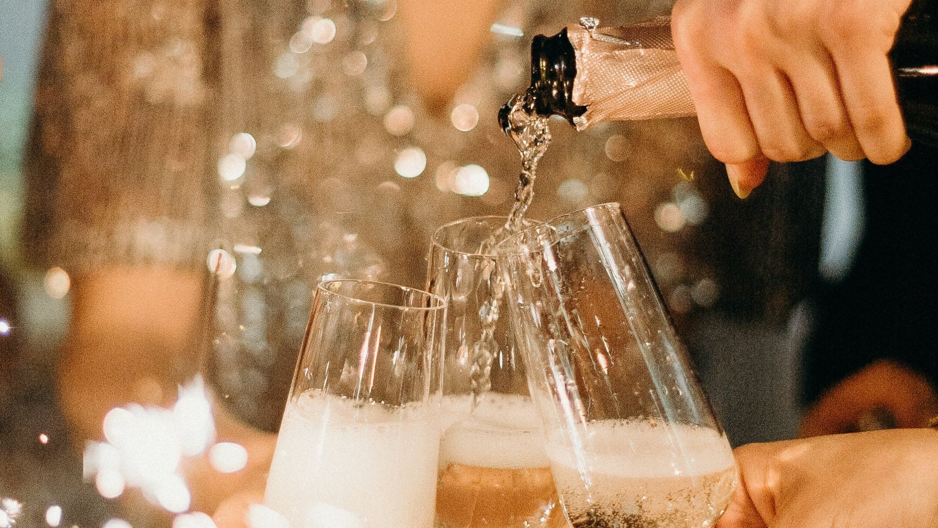 A person is pouring champagne into a glass at a party.