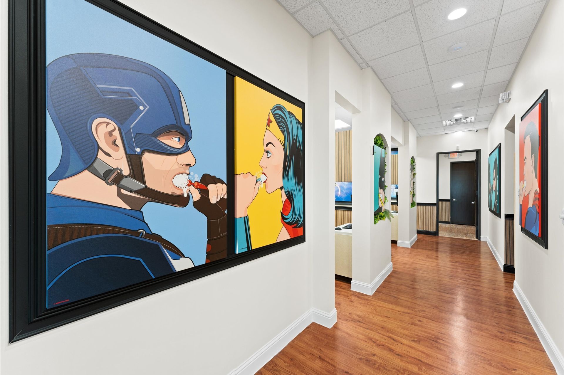 Adventure Dental -Houston A hallway with a painting of captain America and superman on the wall.