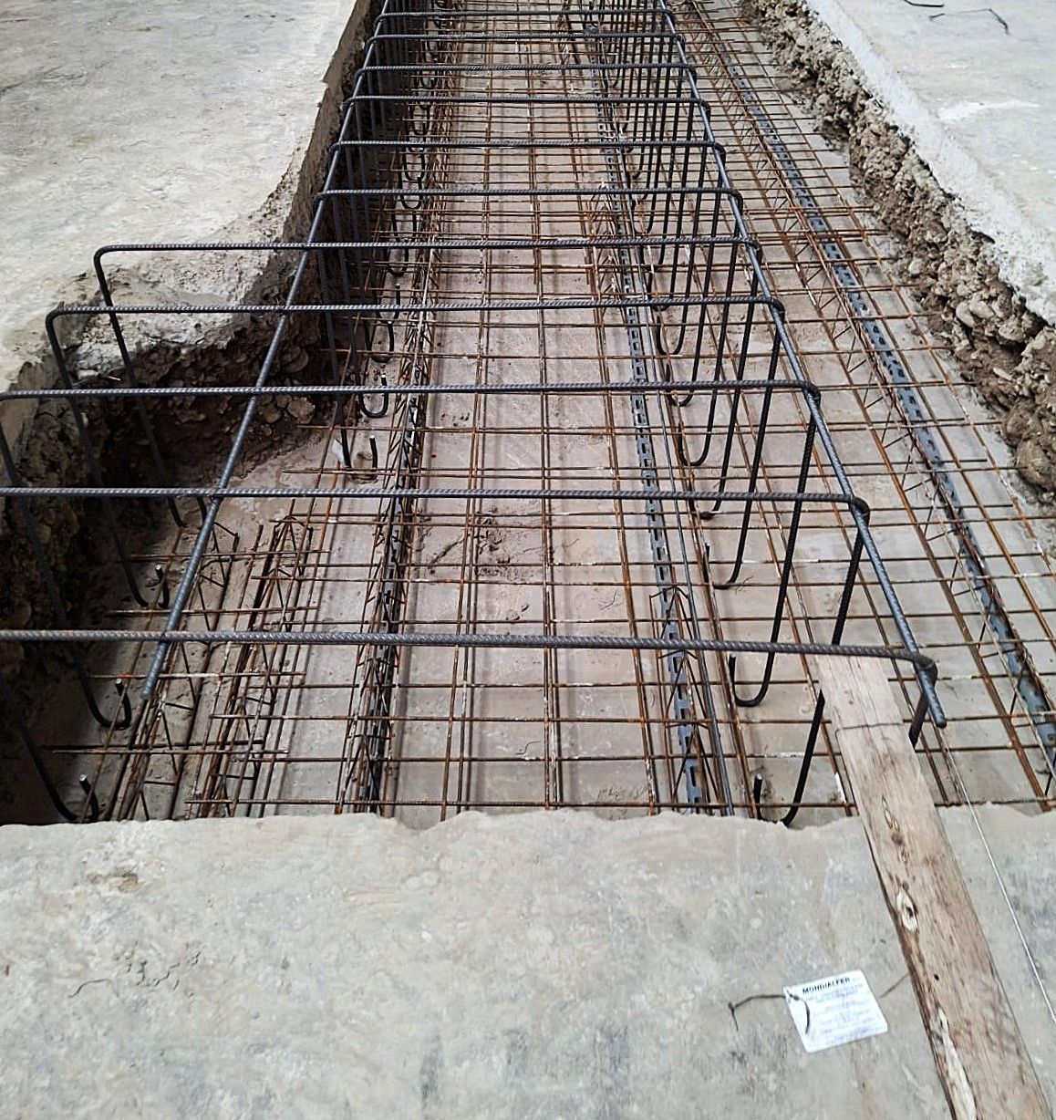 Barre di rinforzo in acciaio in una trincea, preparate per il getto di calcestruzzo.