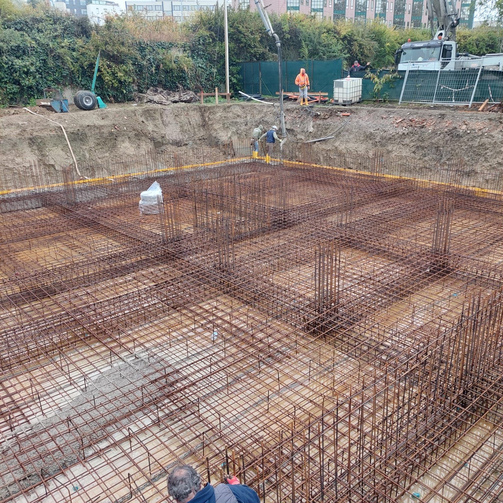 Un edificio giallo ha una piattaforma elevatrice vicino al tetto; sono in corso lavori di costruzione.