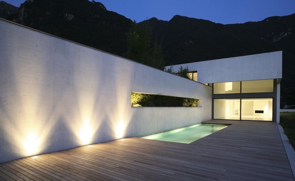 Modern Home Exterior with A Lit Wall, Pool, and Mountain Backdrop at Dusk — Ultra Clear Pool Care in Cranbrook, QLD