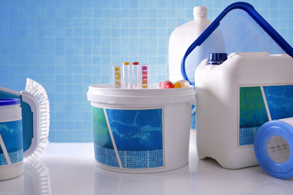Pool Chemicals and Cleaning Supplies Arranged on A White Surface — Ultra Clear Pool Care in Cranbrook, QLD