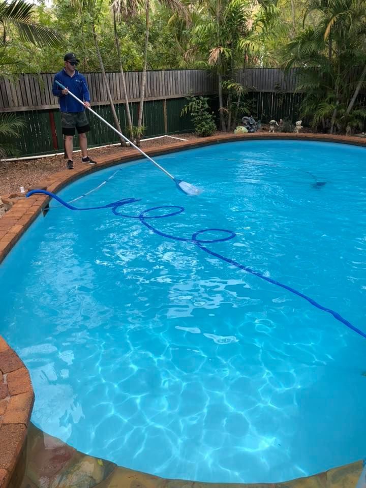 Man Cleaning a Blue Swimming Pool with A Net, Outdoors — Ultra Clear Pool Care in Cranbrook, QLD