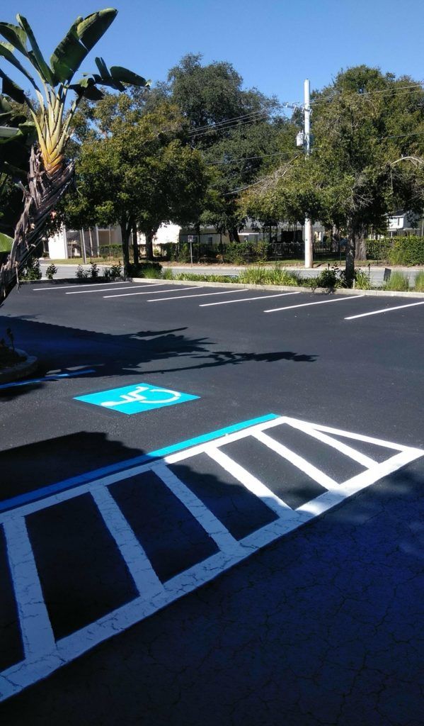 Empty parking lot with blue accessible parking markings and sign.