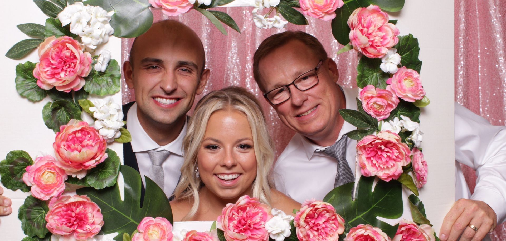 a bride and groom are posing for a picture with their parents in a photo booth .