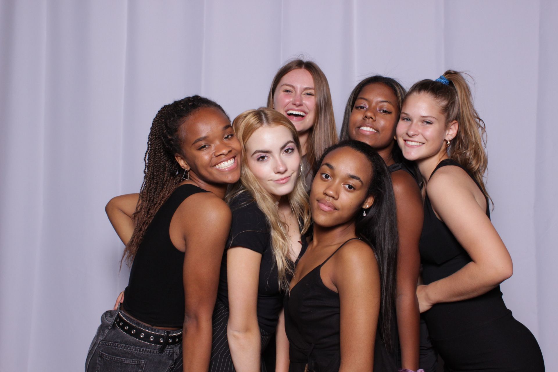 Group of women smiling in front of a white backdrop.