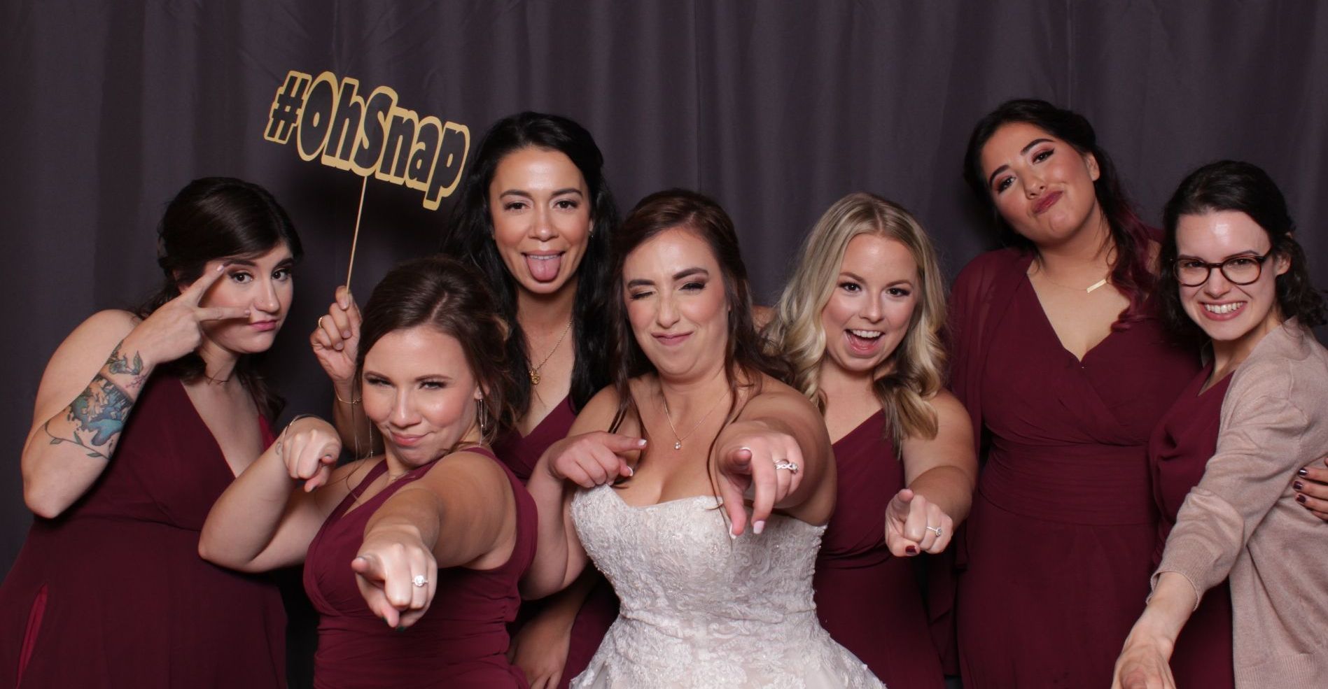 a bride and her bridesmaids are posing for a picture in a photo booth.