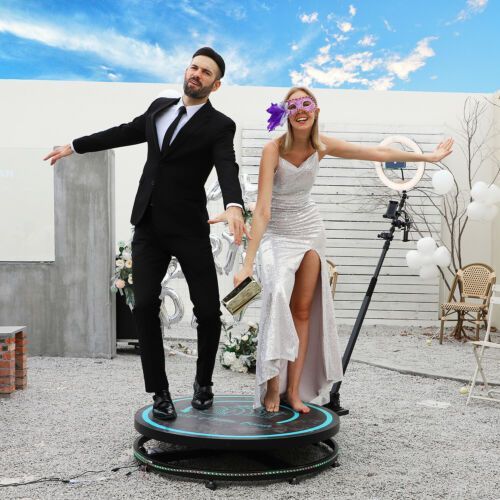 a man and a woman are posing for a picture on a 360 degree photo booth .