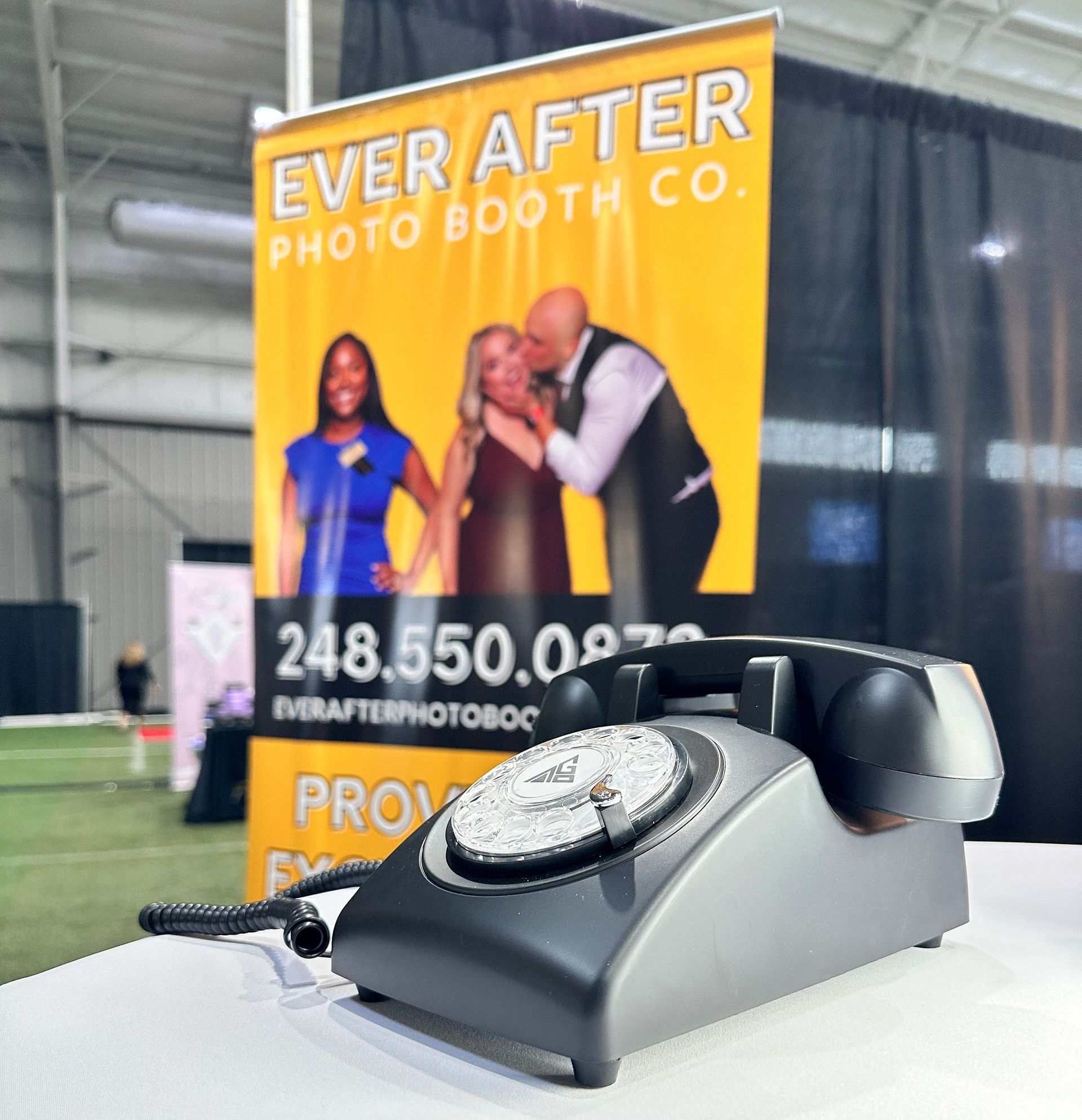 a phone sits in front of a banner that says ever after photo booth co.