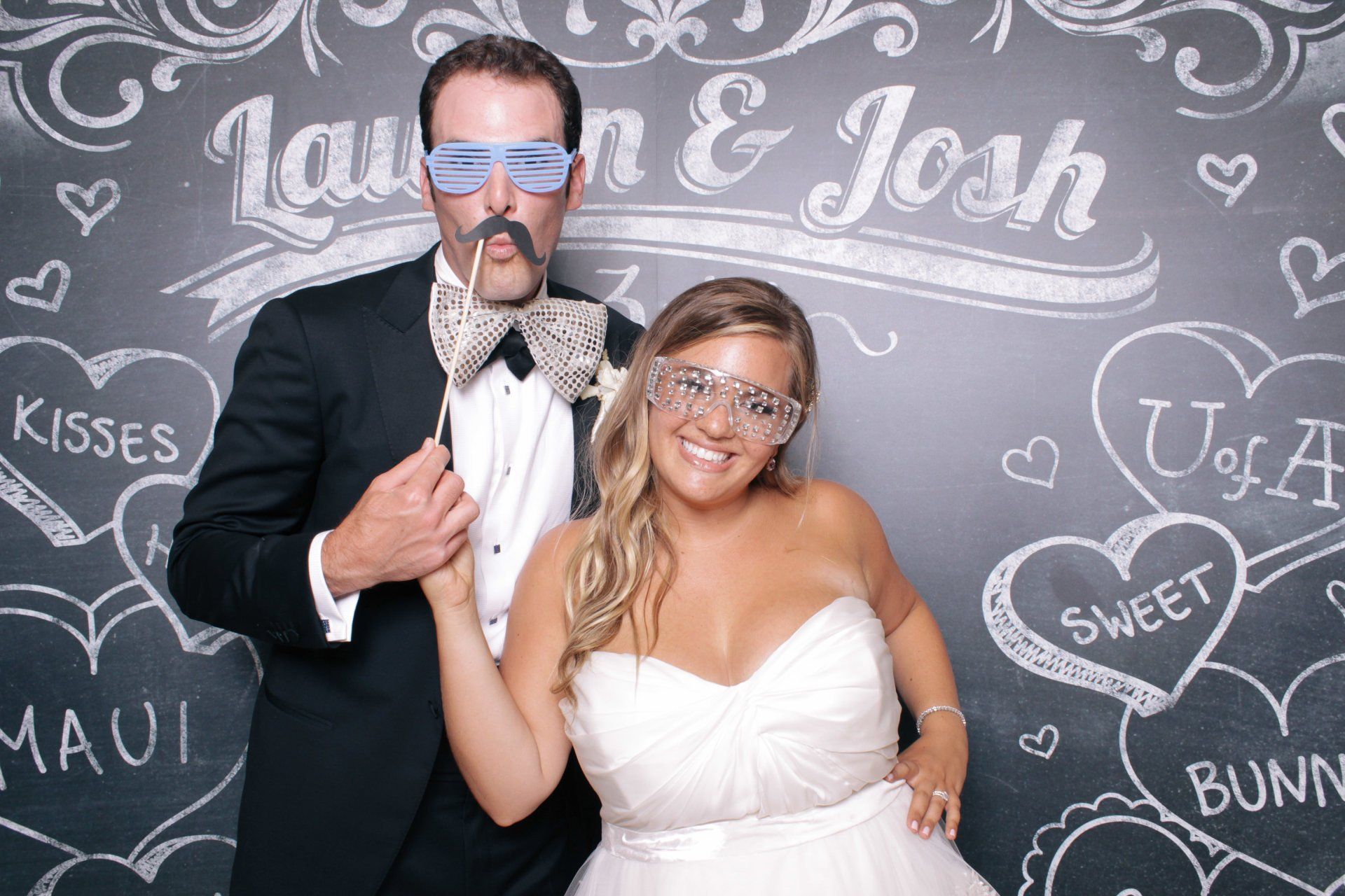 A bride and groom are posing for a picture in a photo booth.