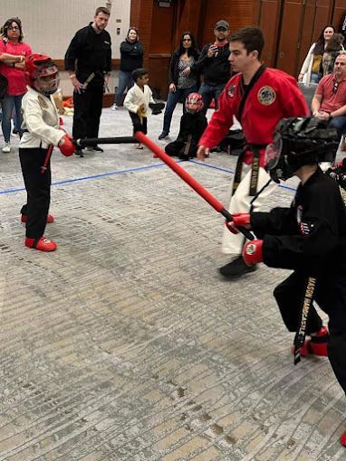 A group of young boys are practicing martial arts in a room.