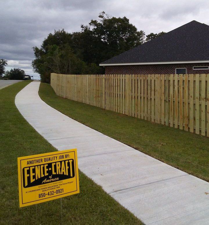 Business Sign and Wood Fence Beside the Sidewalk — Pensacola, FL — A1 Hurricane Fence