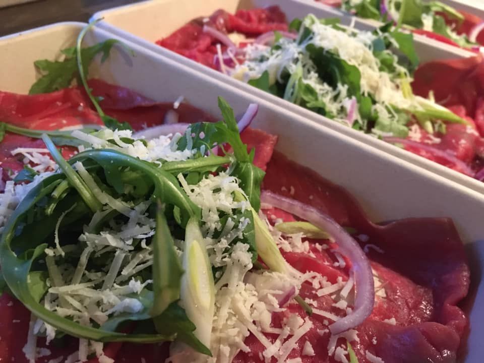 Een close-up van twee borden met eten met vlees en groenten op een tafel.