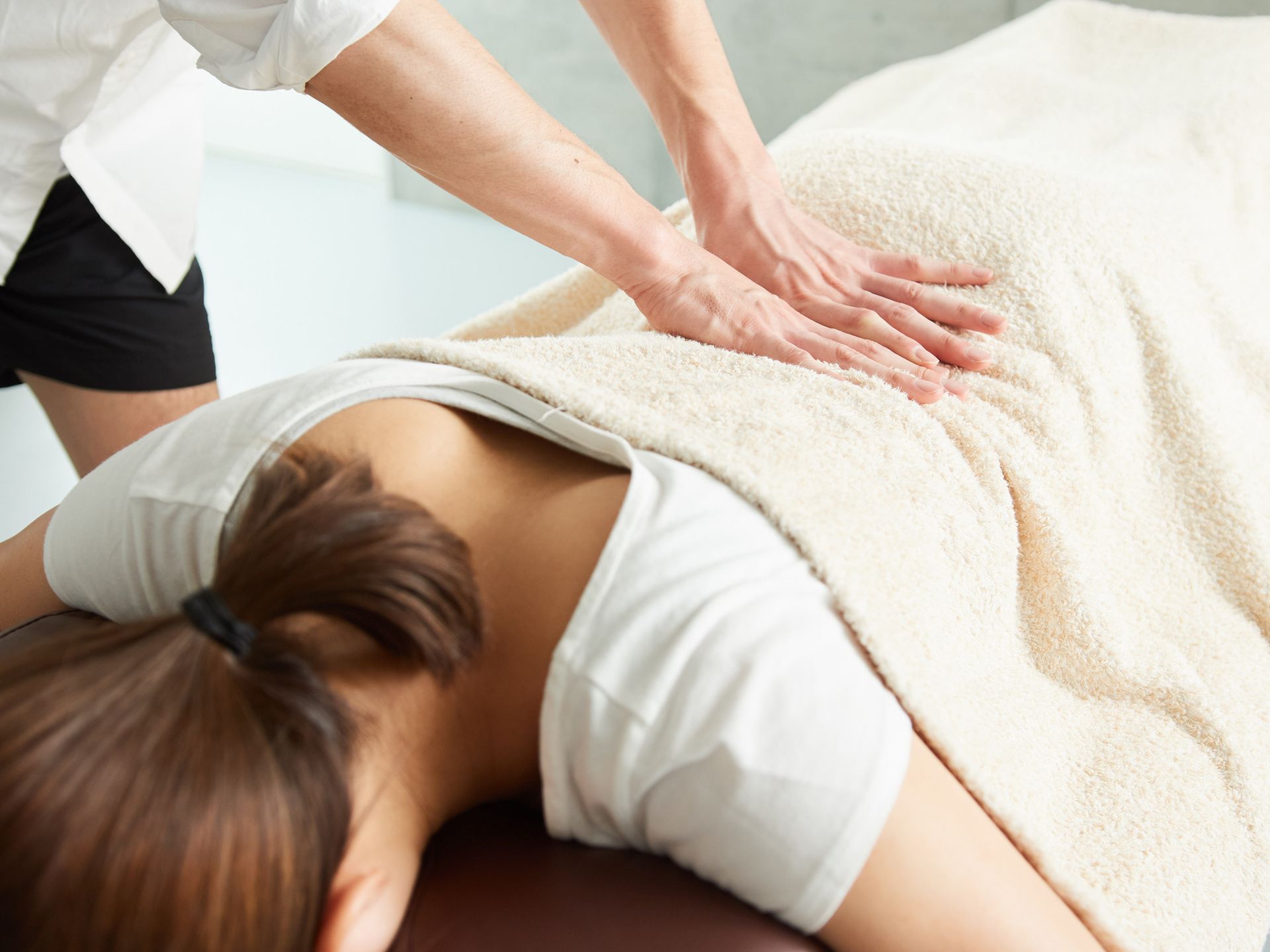 A woman is laying on a table getting a massage.