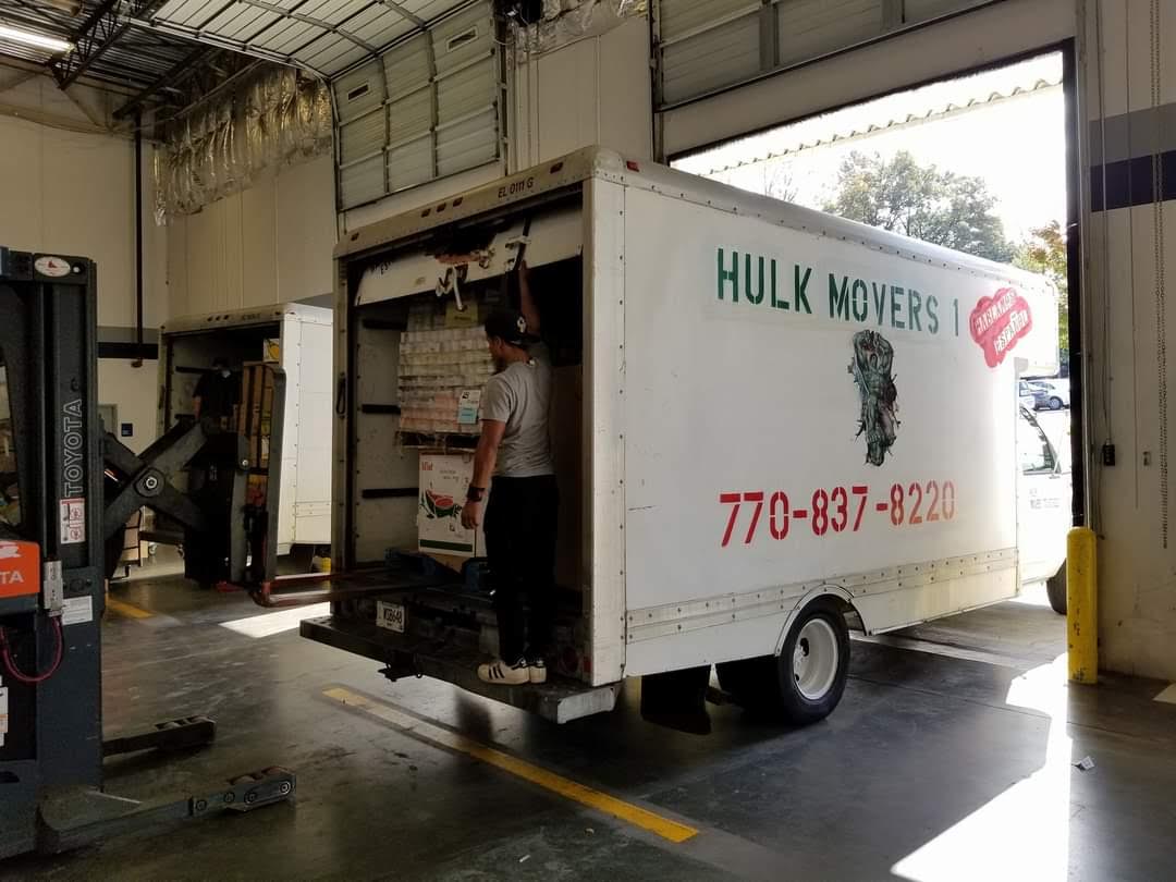 A man is loading a hulk movers truck in a warehouse