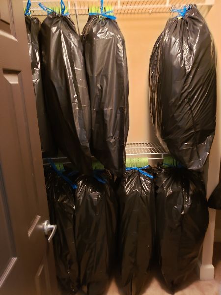 A closet filled with lots of black plastic bags