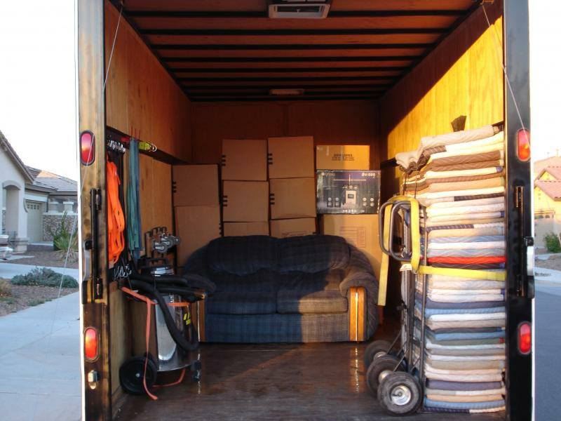 The inside of a moving truck filled with boxes and a couch