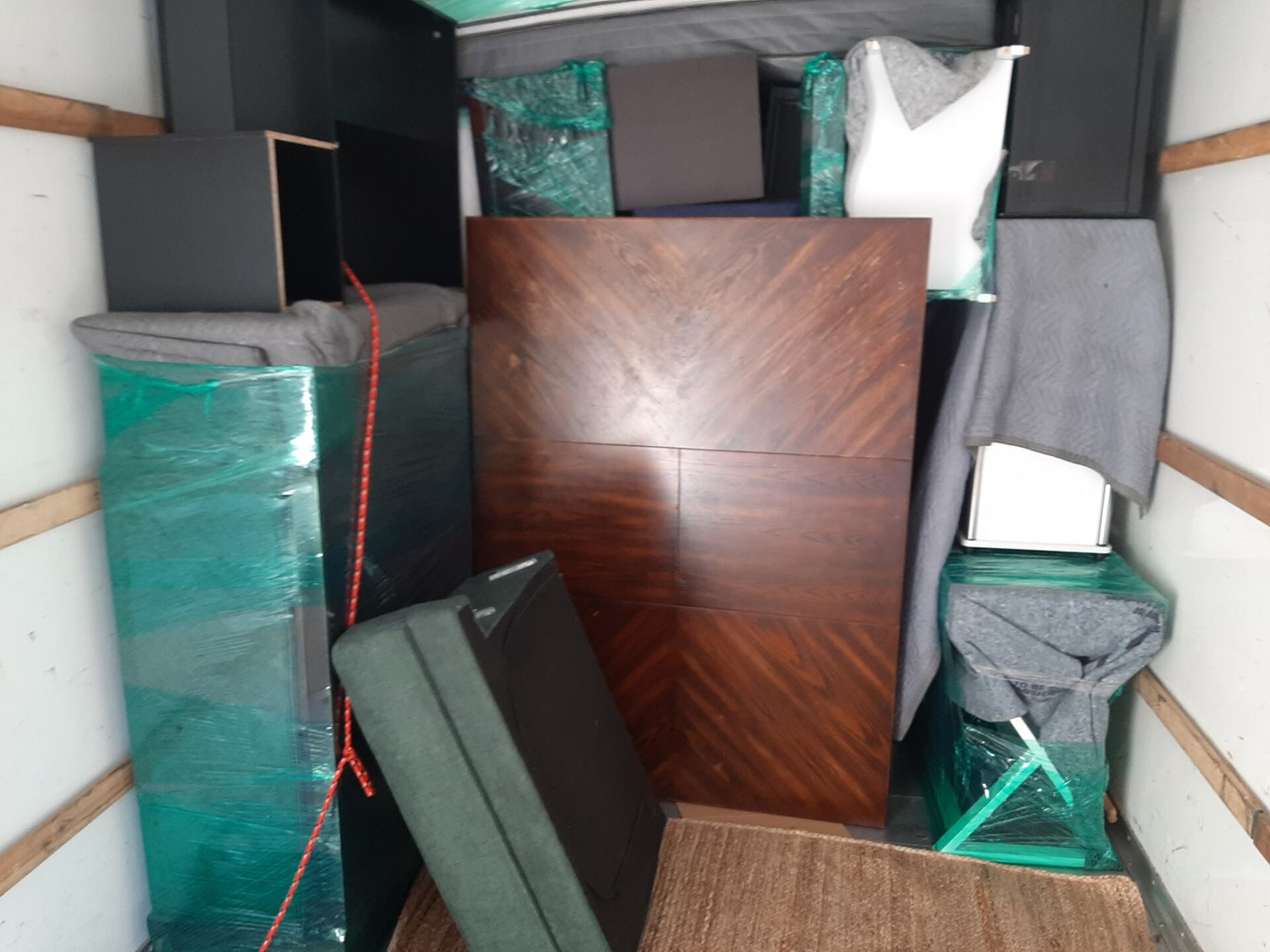 A moving truck filled with lots of furniture and boxes