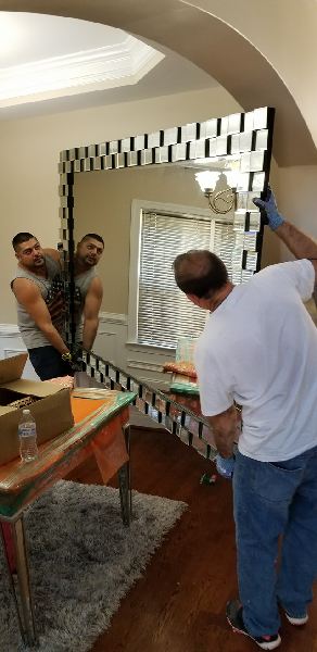 A man is standing in front of a mirror in a room.