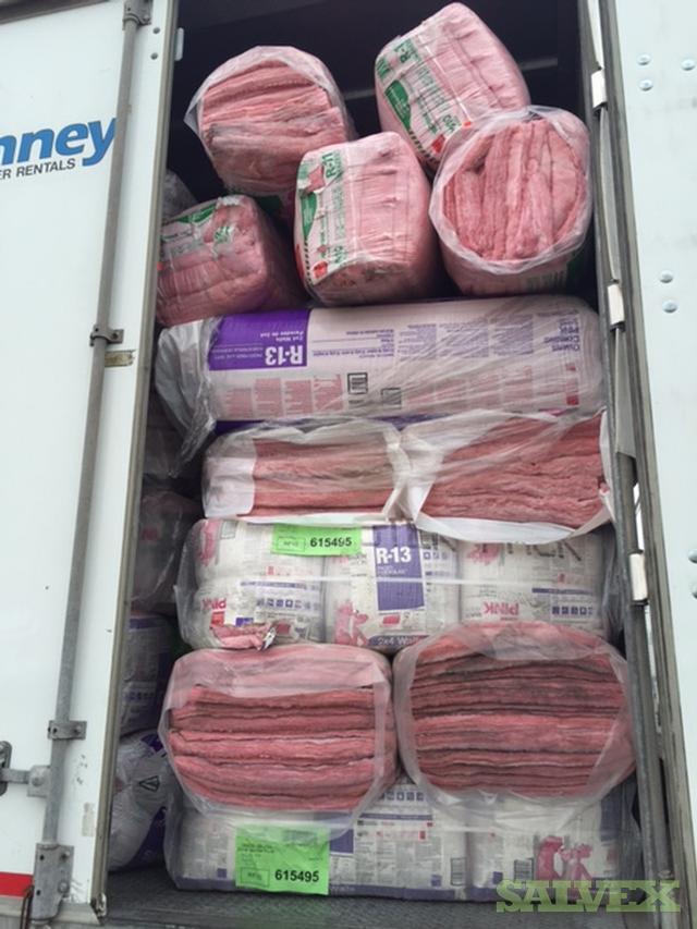 A truck filled with lots of pink rolls of insulation.