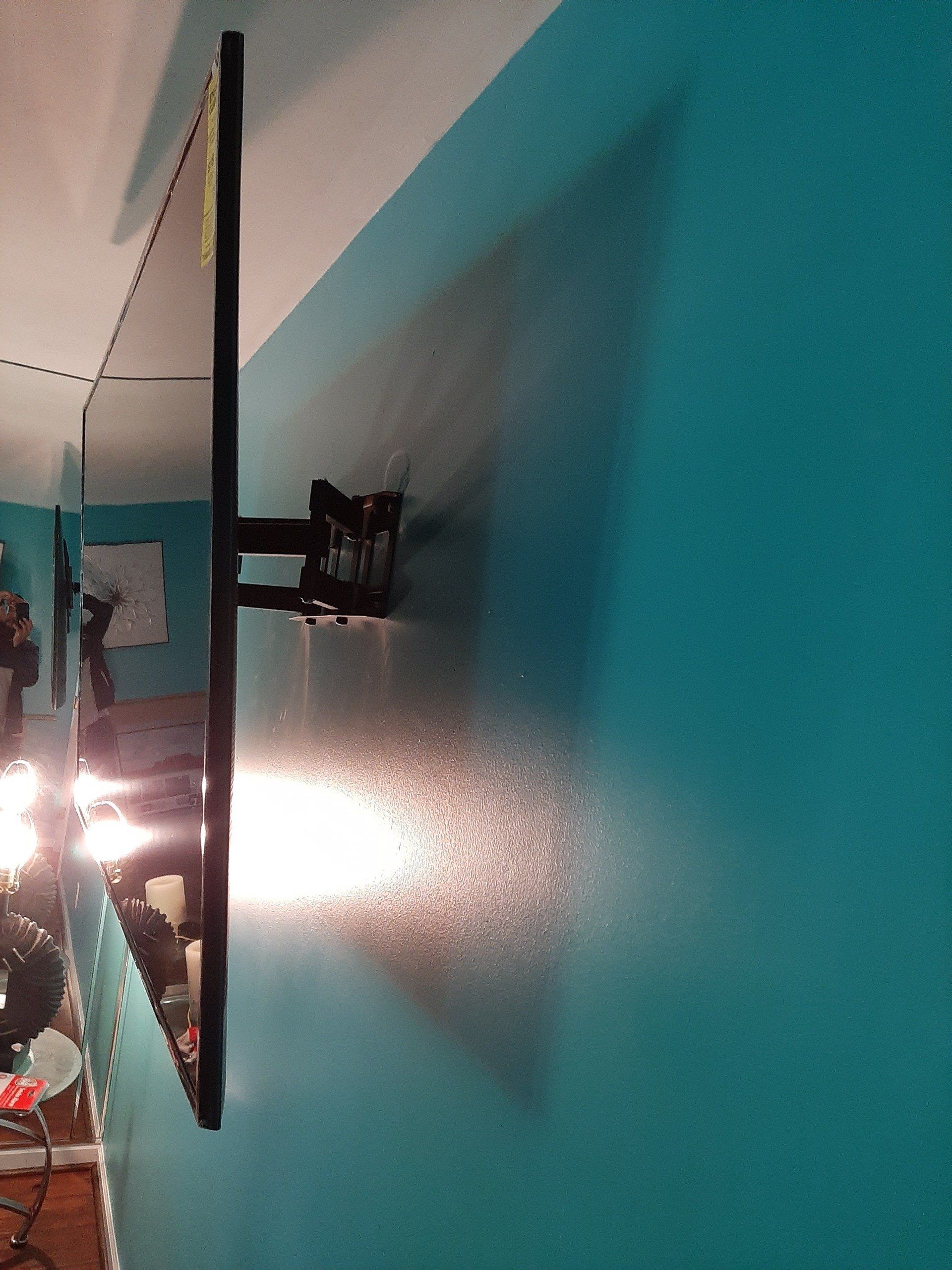 A flat screen tv mounted on a blue wall