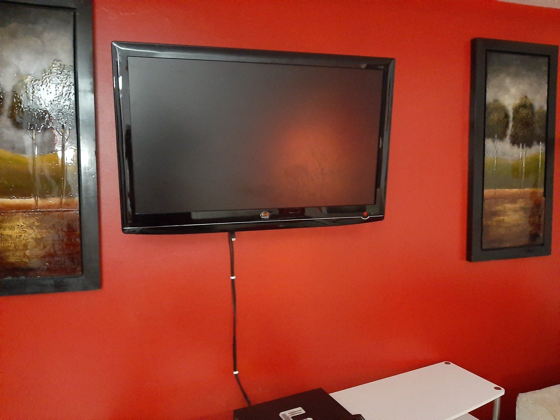 A flat screen tv is mounted on a red wall