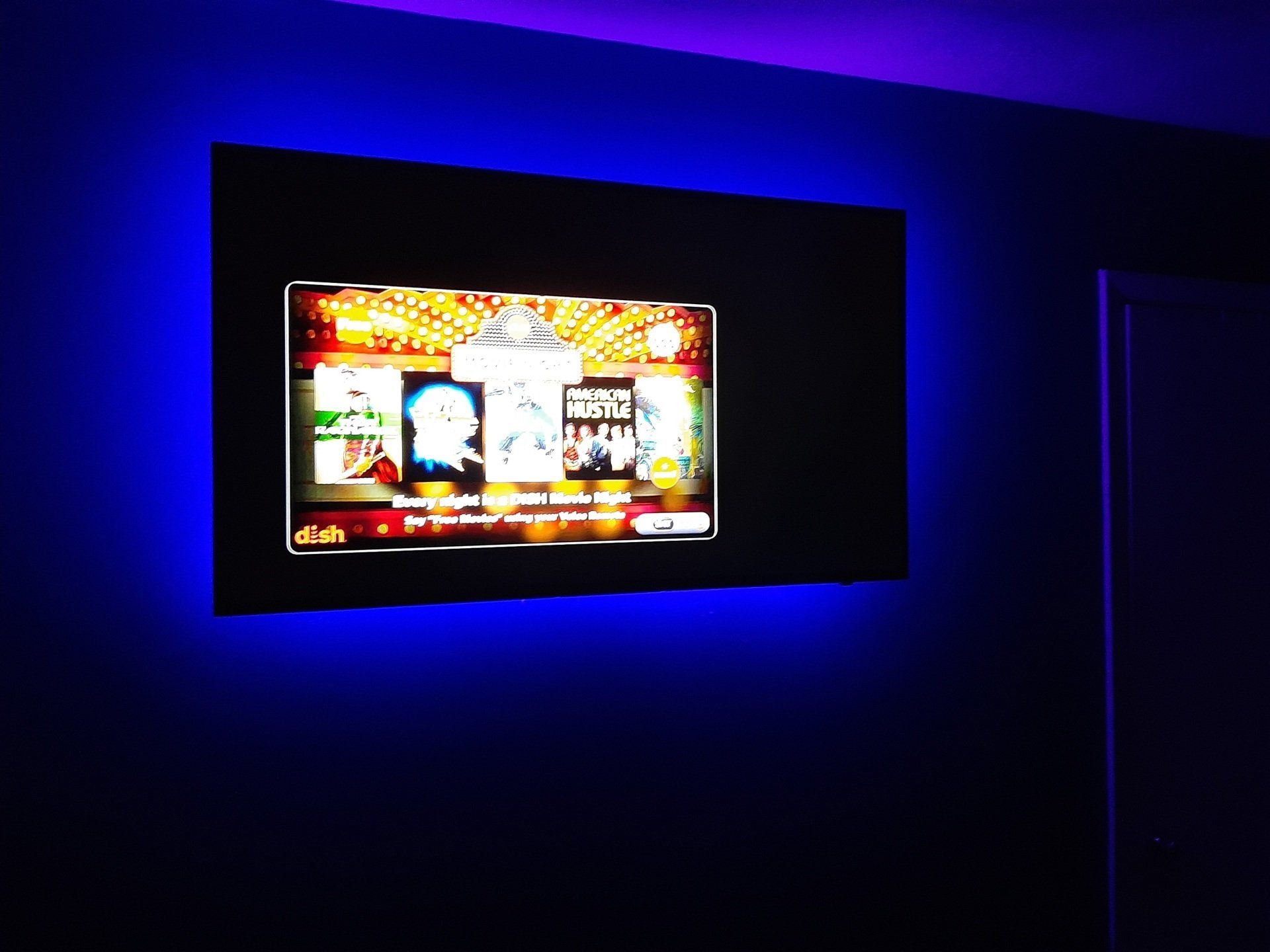 A flat screen tv is lit up with blue lights