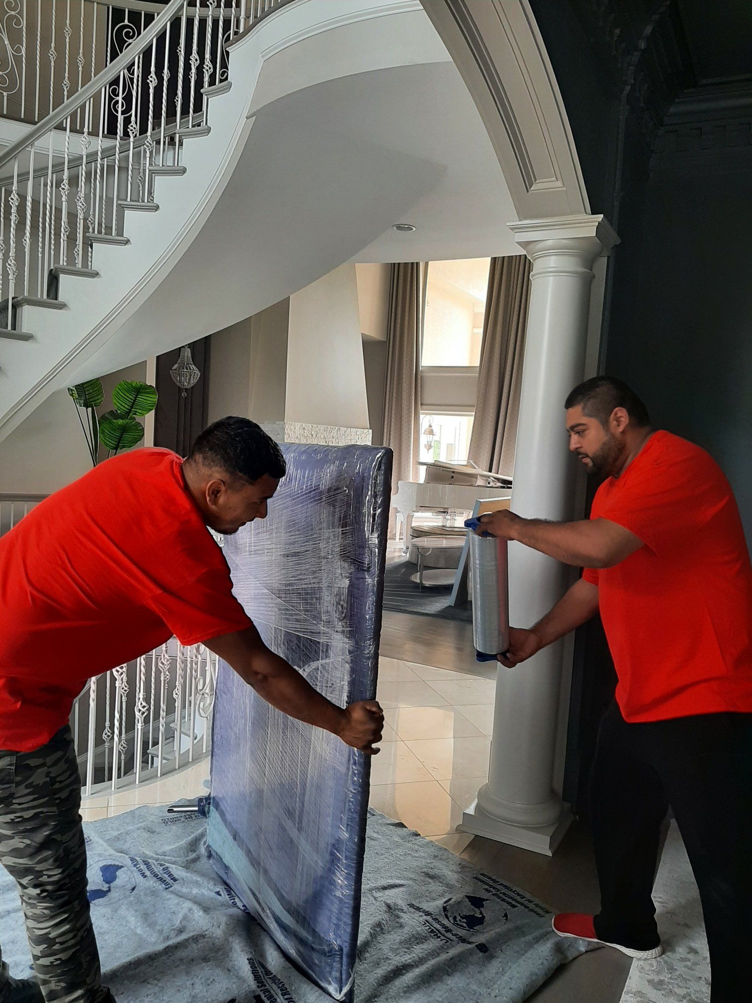 Two men are moving a large piece of furniture in a living room.