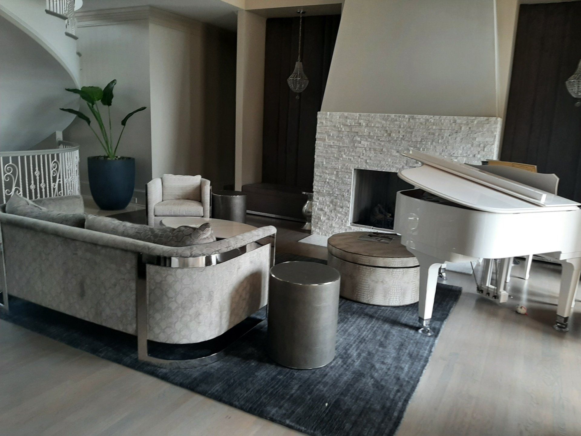 A living room with a white piano and a fireplace