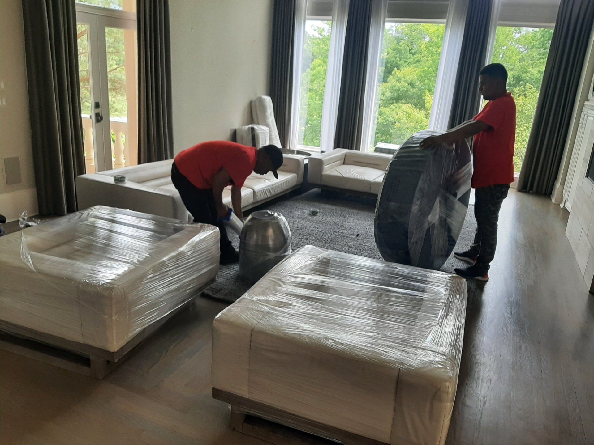 Two men are moving furniture in a living room.