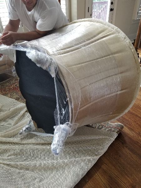 A man is sitting on top of a barrel wrapped in plastic.