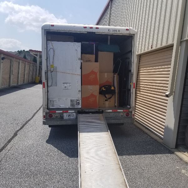 A moving truck is parked in front of a building