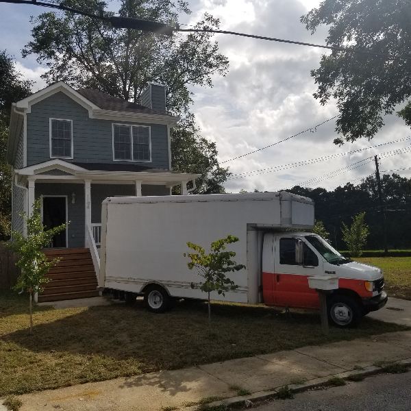A white truck is parked in front of a house