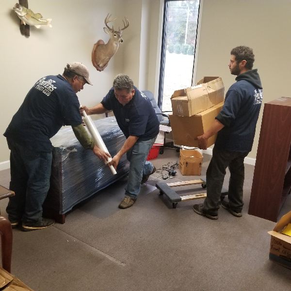 A man wearing a shirt that says ' moving company ' on it